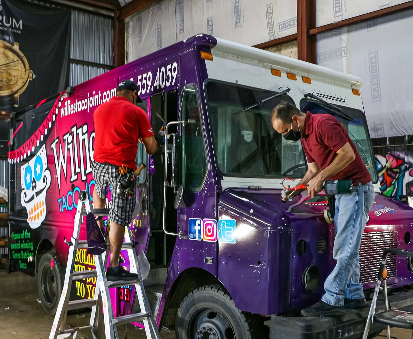 A&M Graphics installers working vinyl on a truck panel